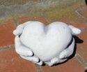 Hænder holder/giver hjerte i hvid beton